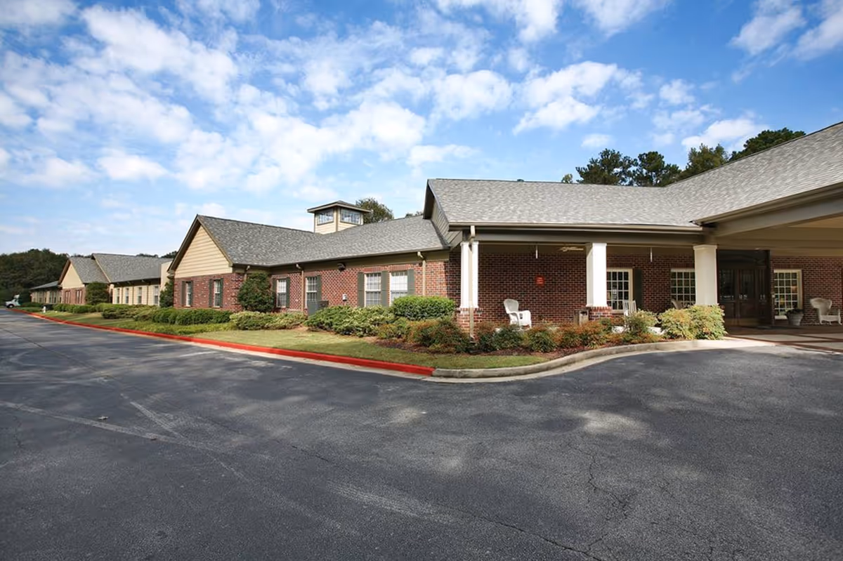 Brick senior living facility with a covered entrance and parking lot.