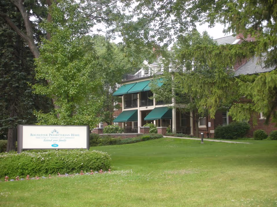 Front view of Rochester Presbyterian Home Creekstone with green awnings and manicured lawn.