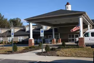 Exterior view of Rich Square Health Care facility entrance with flags and handicapped parking.