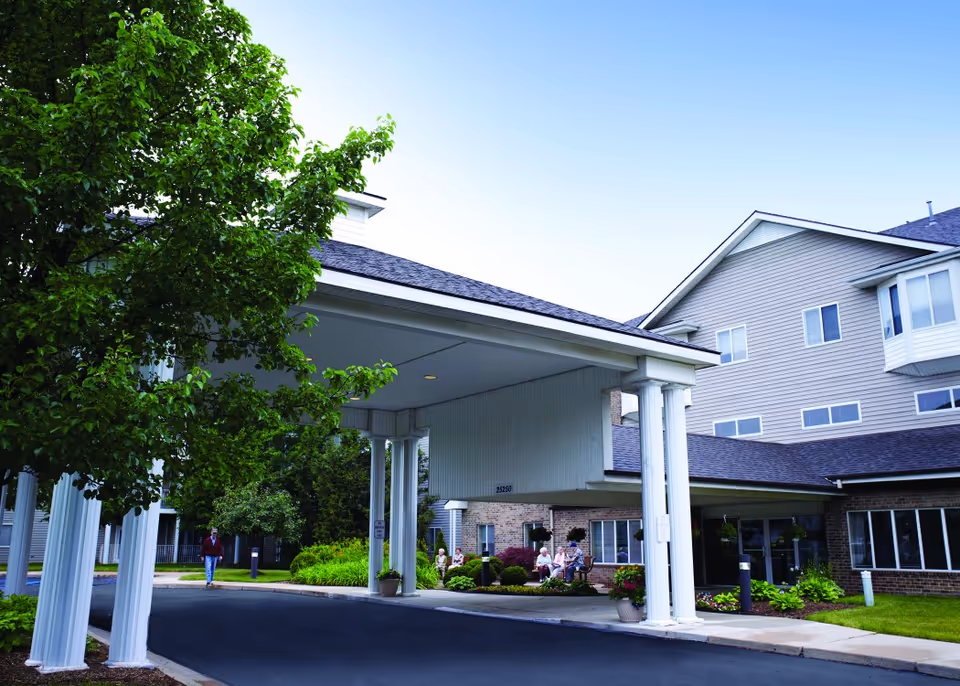Front view of American House Southland with porte-cochere and residents near entrance.