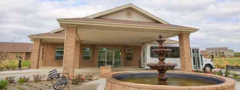 Front view of Remarkable Healthcare of Dallas with brick facade, entrance, and fountain.