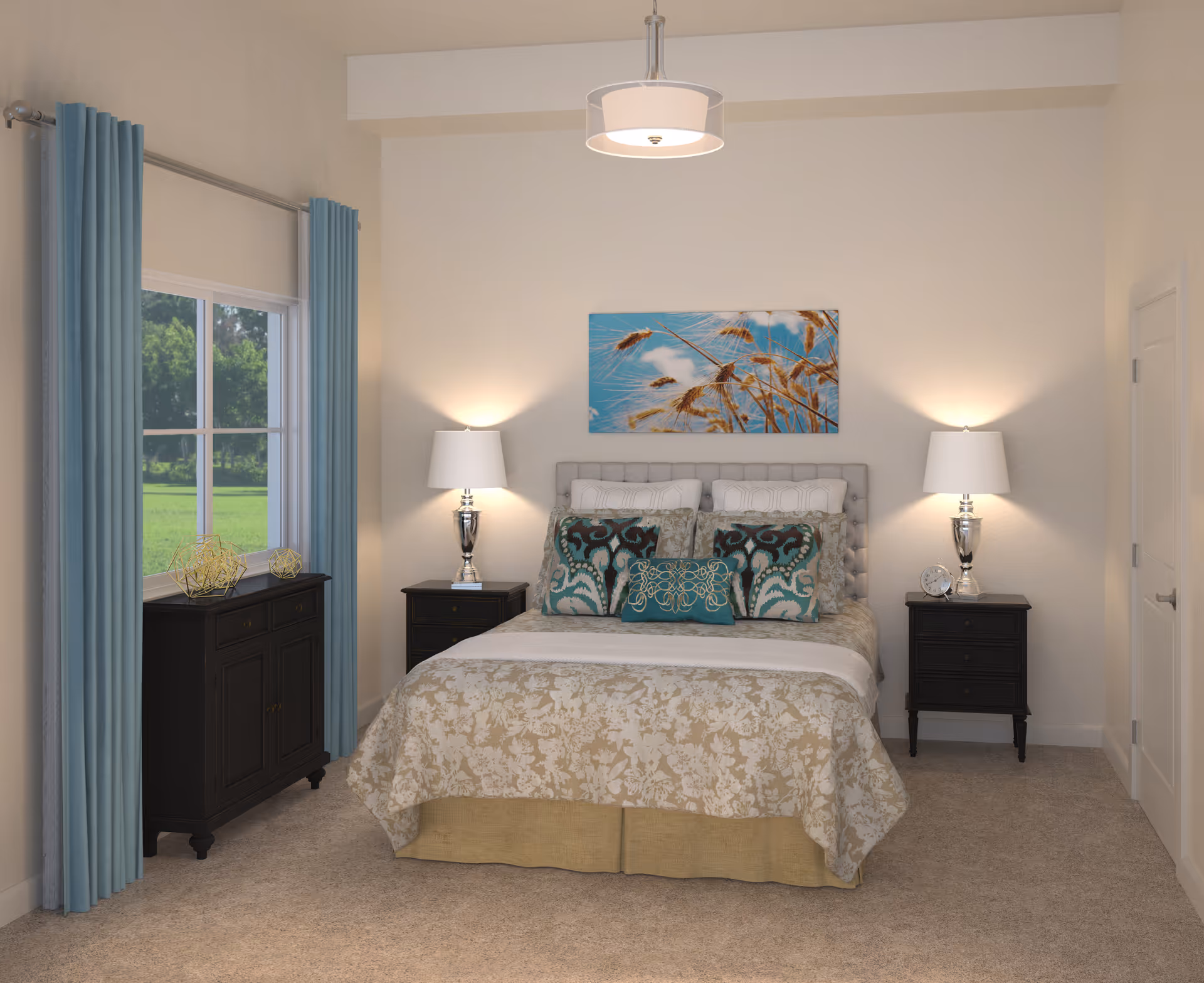A cozy bedroom with a bed centered against a wall, adorned with multiple pillows and a floral-patterned bedspread. Two matching black nightstands flank the bed, each with a silver lamp. A colorful painting of wheat against a blue sky hangs above the bed. To the left, a window with light blue curtains lets in natural light, and a black cabinet sits beneath the window. The room has beige carpeting and light-colored walls.