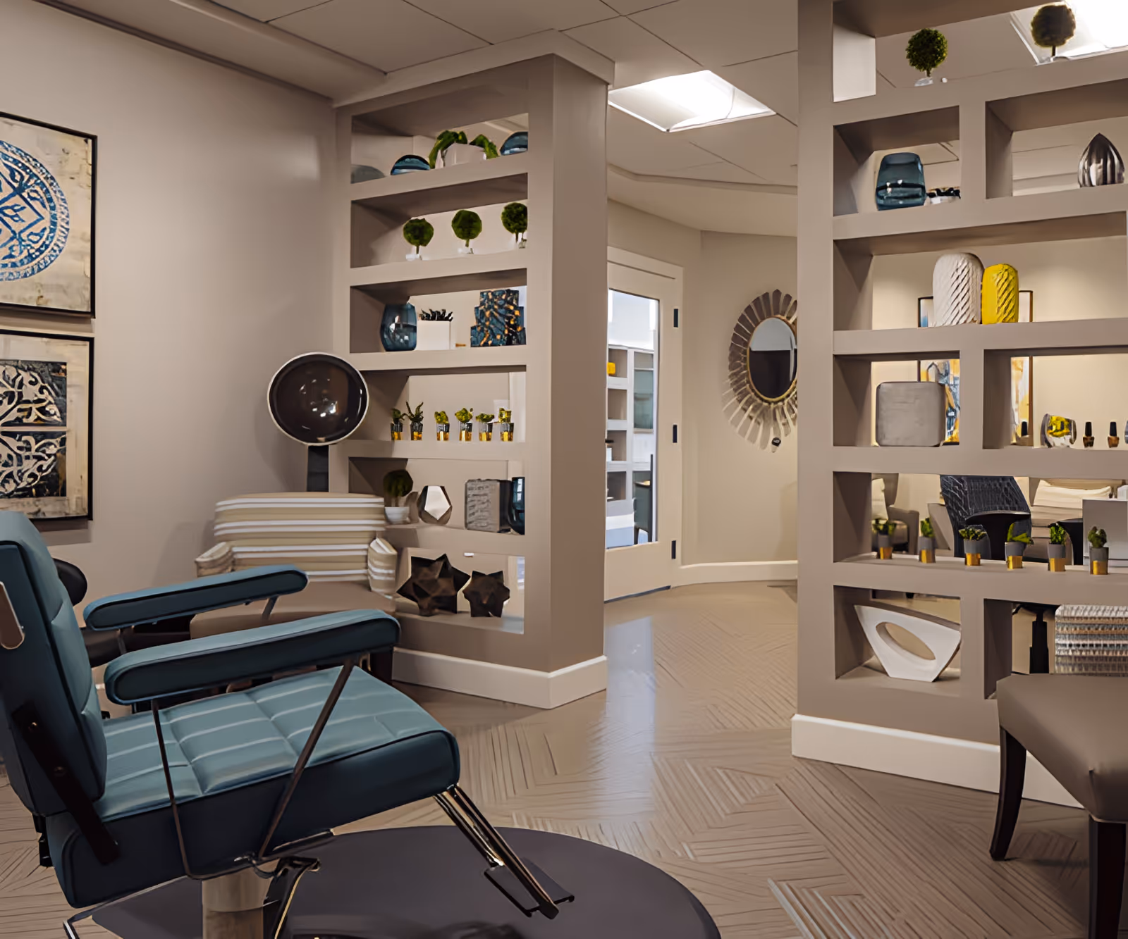 Interior view of a stylish assisted living facility room featuring a blue reclining chair, a striped armchair, decorative shelving with plants and art pieces, a round mirror on the wall, and a modern floor design.