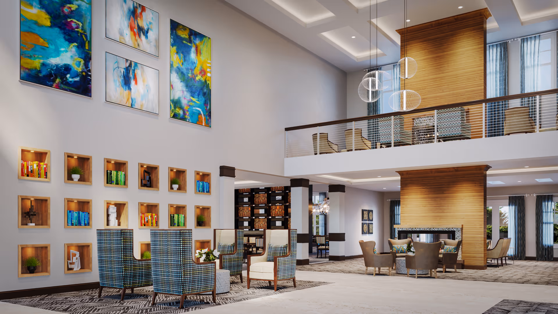 Spacious and modern senior living facility common area with high ceilings, contemporary hanging light fixtures, and a two-level layout. The lower level features comfortable seating with armchairs arranged around small tables, a fireplace with wooden paneling, and built-in wall shelves displaying colorful books and decorative items. The upper level has additional seating with chairs and tables, separated by a railing. Large abstract paintings adorn the walls, and natural light filters through tall windows with curtains.