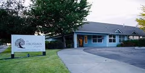 Homestead Place senior living facility: a single-story blue building with a front entrance and sign.