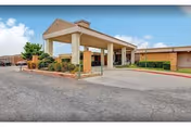 Covered porte-cochere entrance of a single-story senior care facility with a drive-up area and landscaped beds.