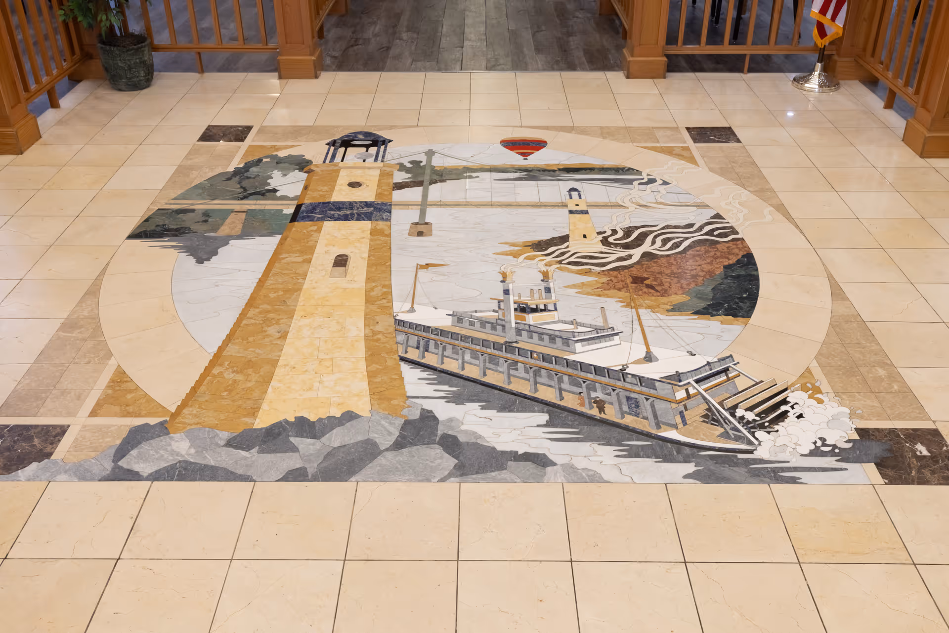 Lobby floor mosaic depicting a steamboat and lighthouse set into a tiled interior space.