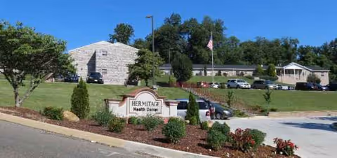 Exterior view of Hermitage Health Center with a sign and landscaped entrance.