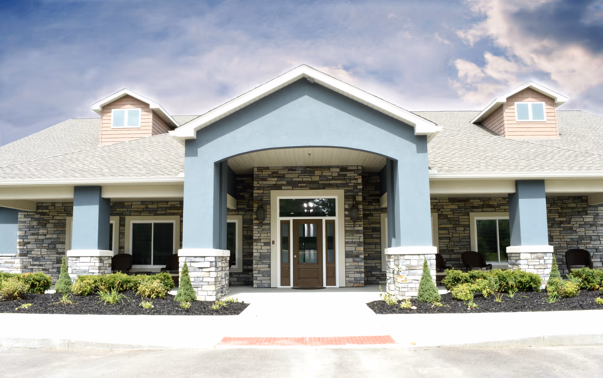 Front view of BeeHive Homes of Oxford exterior with stone pillars and a covered entrance.