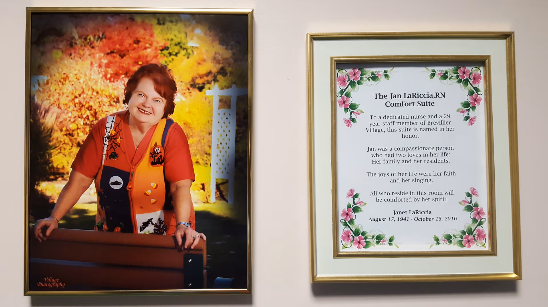 Two framed items hanging on a wall. The left frame contains a portrait of a smiling woman with red hair wearing a colorful vest and red shirt, standing outdoors with autumn foliage in the background. The right frame contains a dedication plaque titled 'The Jan LaRiccia, RN Comfort Suite' honoring a nurse named Jan LaRiccia, with floral decorations around the text.
