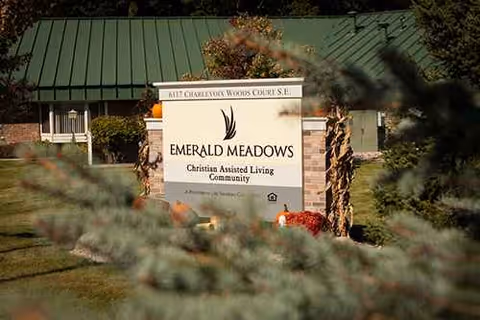 Exterior view of a senior living facility with a sign reading Emerald Meadows