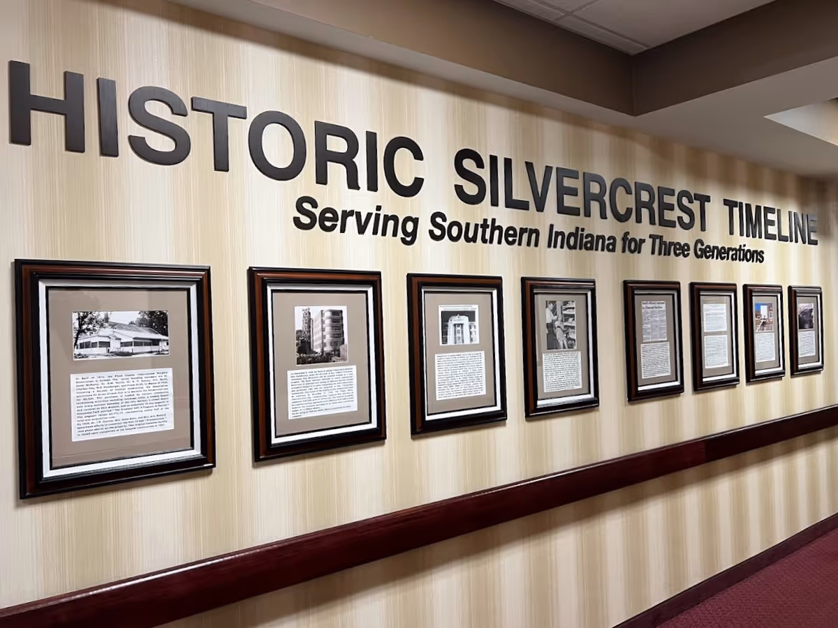 Interior hallway wall with large 'Historic Silvercrest Timeline' lettering and a row of framed historical photos and descriptions.