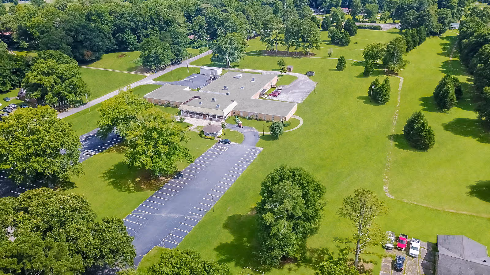 Aerial view of Front Porch of Bowdon Senior Living shows parking and expansive green lawns.