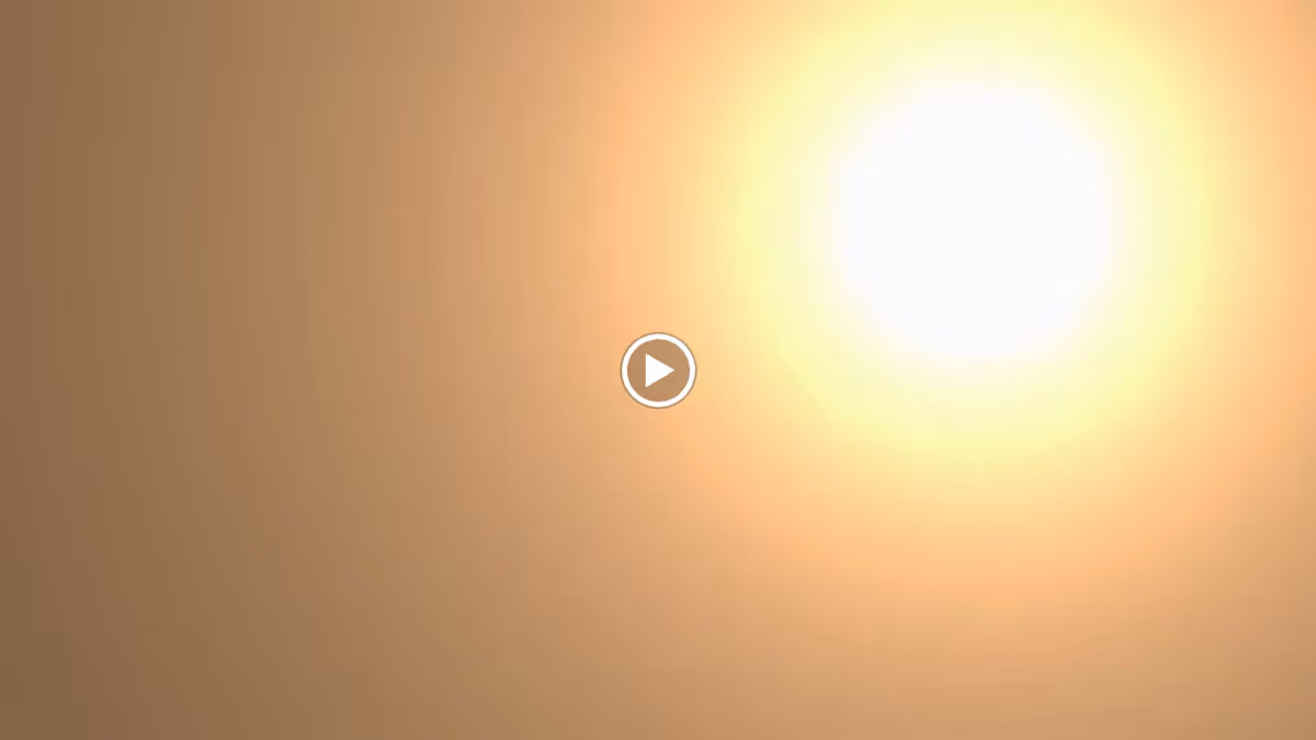 Bright sun shining in a clear sky with a warm golden hue.