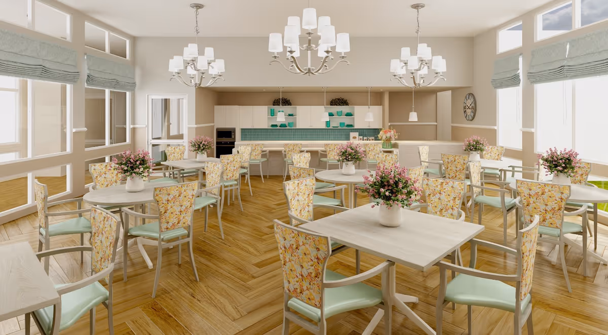 Bright dining room with floral-upholstered chairs, multiple tables topped with flower vases, chandeliers, and a serving counter in the background.