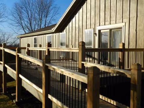 Exterior view of Clover Care Home showing a wooden ramp and railing along the building.
