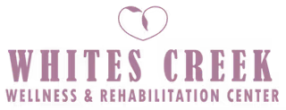 A bold sign displaying 'WHITES CREEK WELLNESS & REHABILITATION CENTER' with a heart graphic on a dark background.