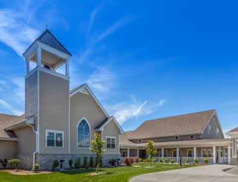 Exterior view of Brookestone Acres building with a tower and landscaped entrance.