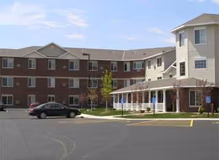 Exterior view of The Rose of Ames: brick building, covered entrance, and parking lot.