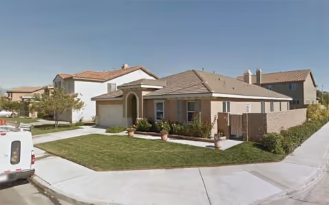 Exterior view of Alpine Care Assisted Living, a single-story building with a manicured lawn.