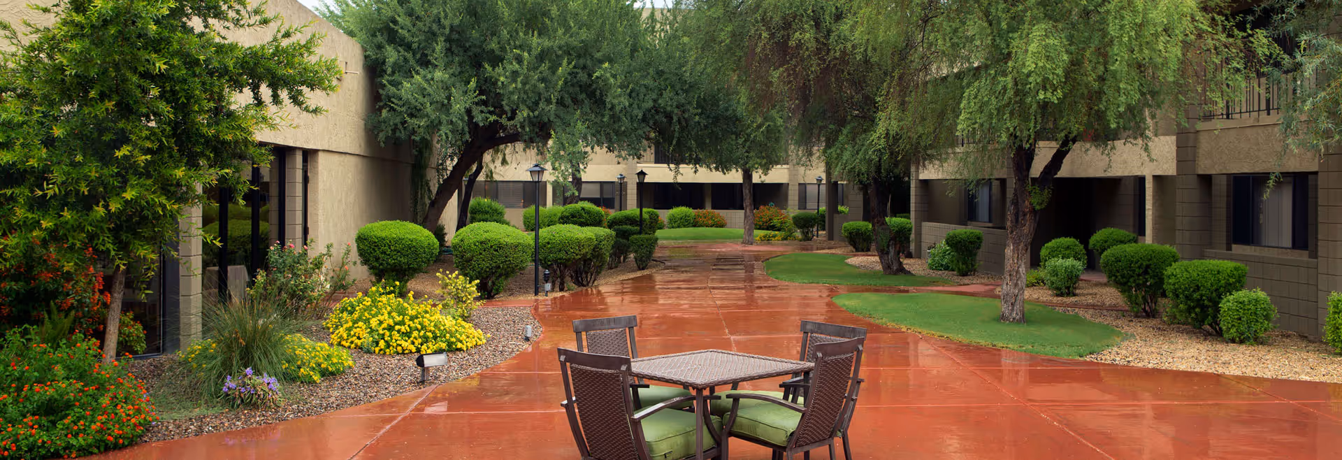 Outdoor courtyard at Lifestream at Thunderbird with table, chairs, and manicured landscaping.