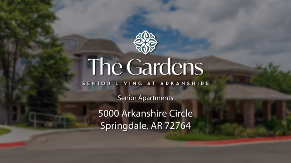 Front entrance of The Gardens senior living building with overlaid logo, name, and address.