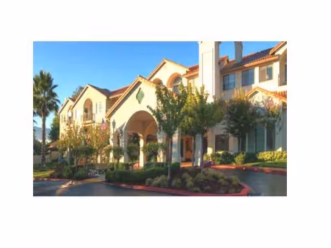 Fountaingrove Lodge exterior with arched entrance, palm trees, and landscaping.