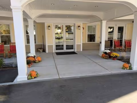 Exterior entrance with pumpkins and chairs under a covered front porch at Inn at Parker Station