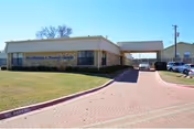 Exterior view of Coral Rehabilitation and Nursing of Arlington with a brick walkway to the entrance.