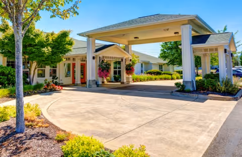 Exterior view of Callahan Court Memory Care entrance with porte-cochère and landscaped drive.