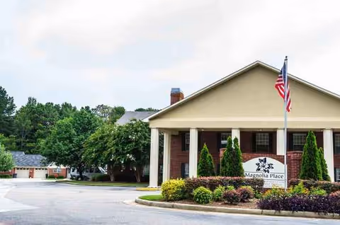 Front view of Summer Village Magnolia Place with flag and landscaped entrance.