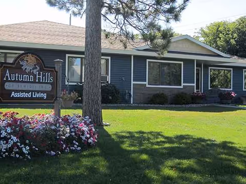 Front view of Autumn Hills Assisted Living facility with sign and landscaped lawn.