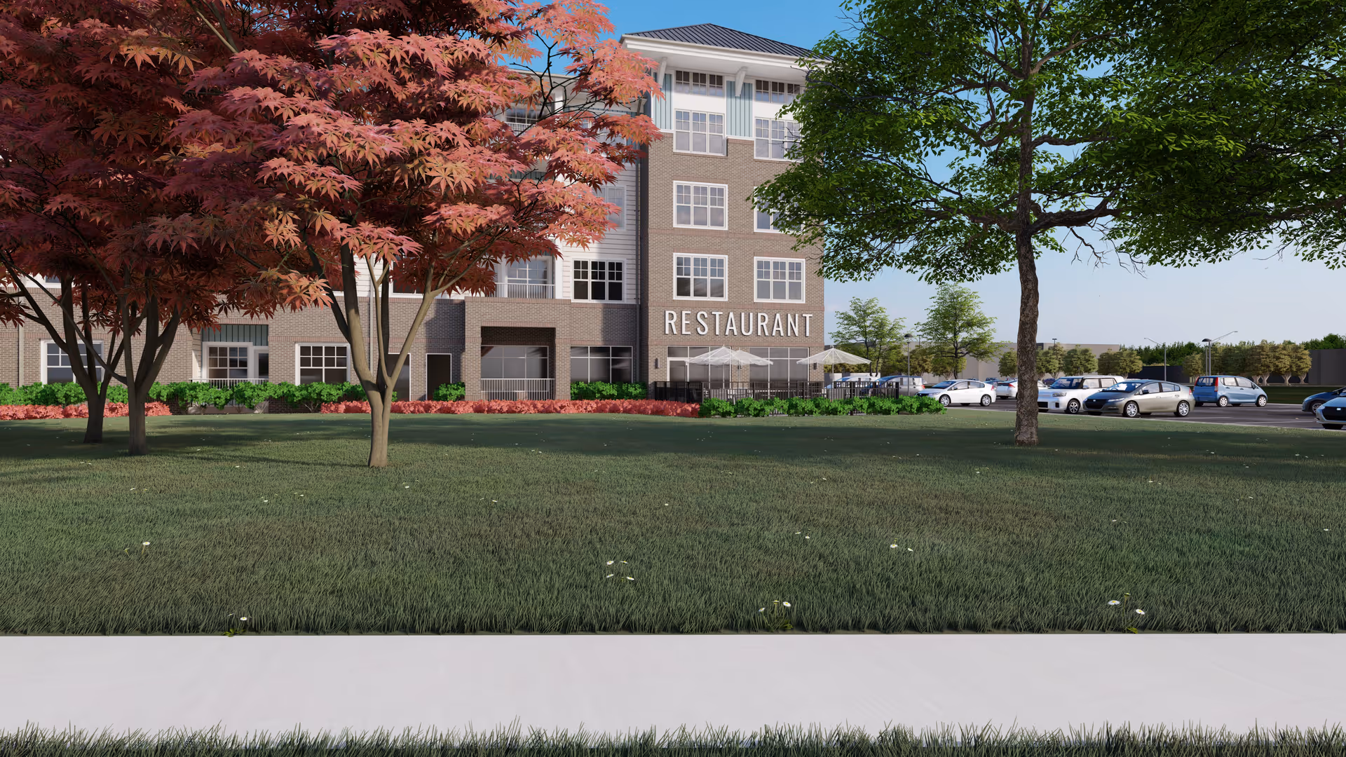 Exterior view of a multi-story building with a restaurant on the ground floor. The building is surrounded by green grass, trees with red and green leaves, and a parking lot with several cars. The sky is clear and blue.