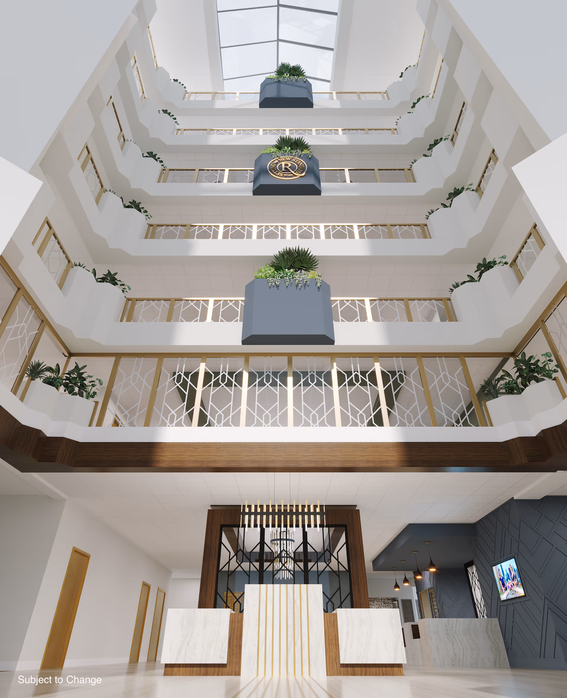 Interior view of a multi-story atrium with balconies on each floor, decorated with plants and a large emblem featuring the letter R. The ceiling is glass, allowing natural light to illuminate the space. Below is a modern reception desk area with marble and wood finishes, pendant lighting, and a television mounted on a dark textured wall.