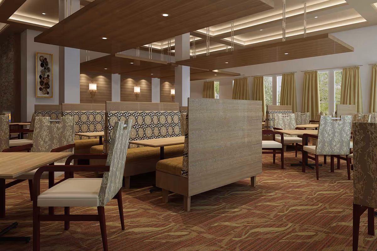 Spacious dining room with upholstered booths, patterned chairs, wooden tables and warm overhead lighting.