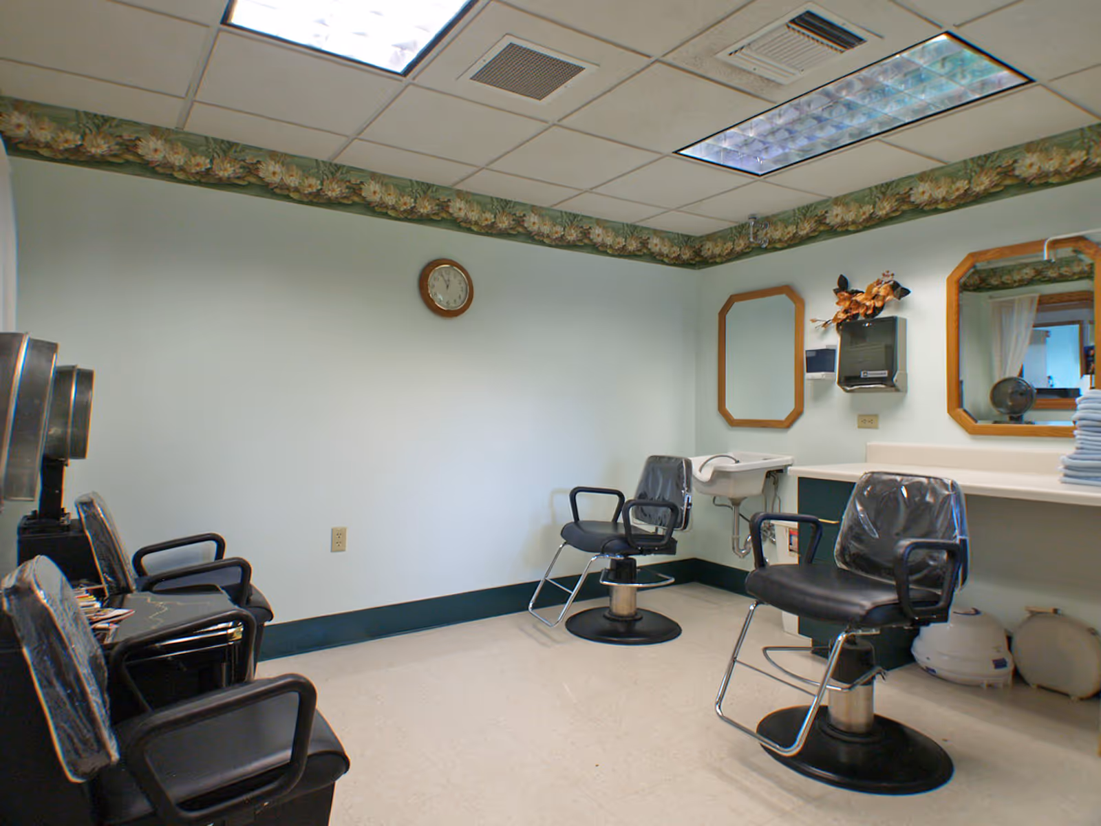 Small salon room with barber chairs, mirrors, and styling stations.