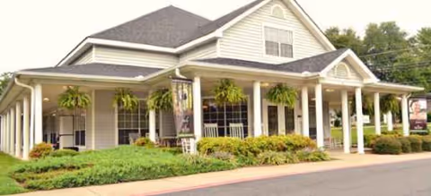 Exterior view of Brookdale Hartwell senior living facility with a covered front porch and hanging plants.