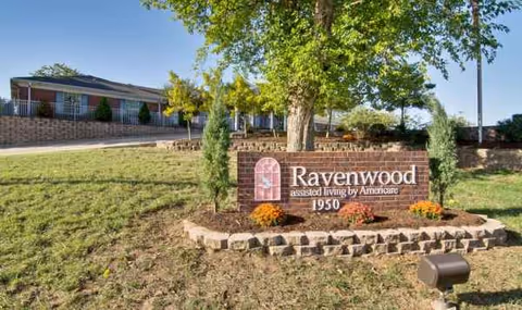 Ravenwood Senior Living entrance sign on a landscaped lawn with building in background