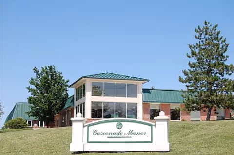 Front exterior of Gasconade Manor Nursing Home building with a lawn and a white sign reading 'Gasconade Manor'.