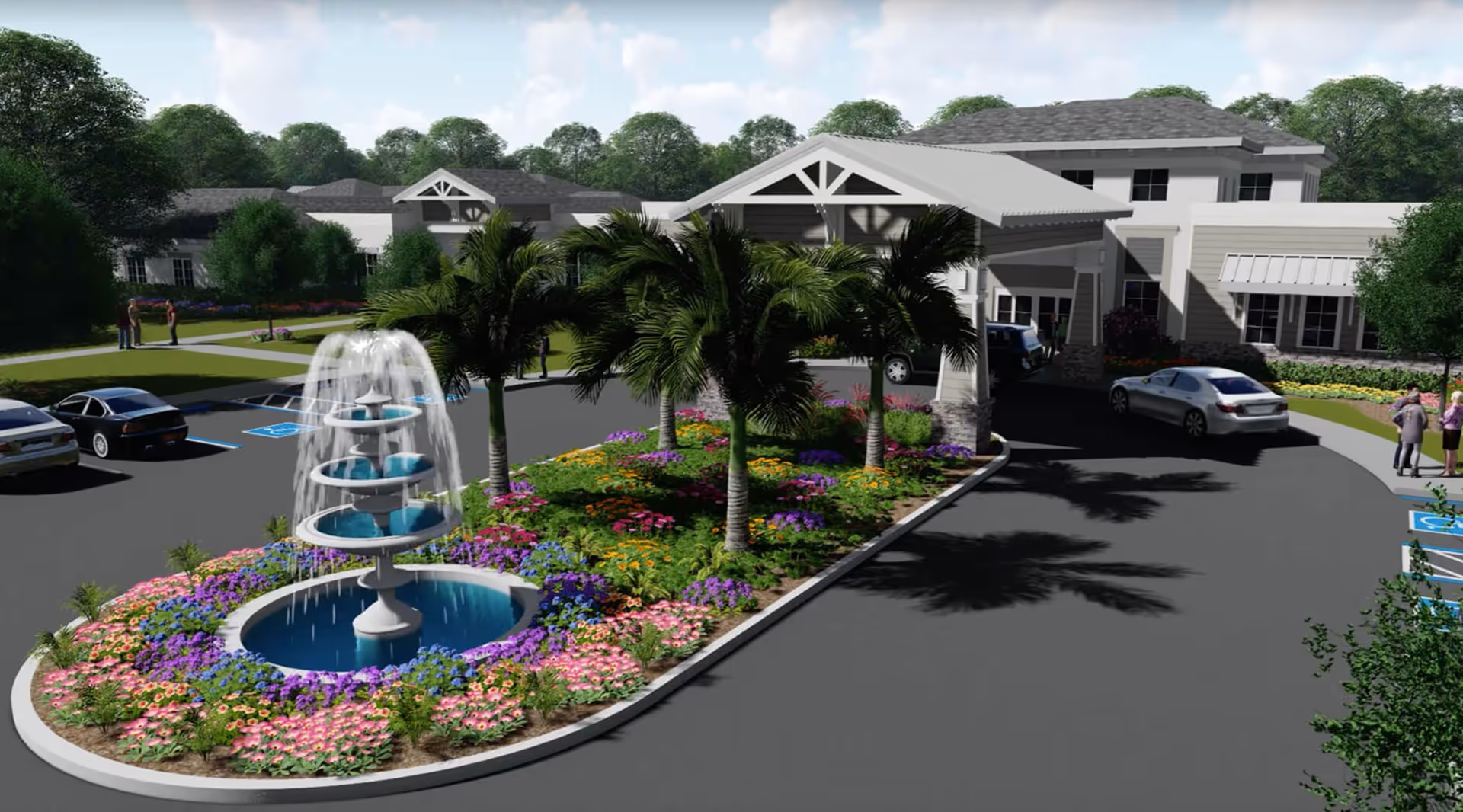 Entrance of a senior living facility with a covered drop-off area, a multi-tiered water fountain surrounded by colorful flowers and palm trees, several parked cars, and a few people standing and conversing near the building.