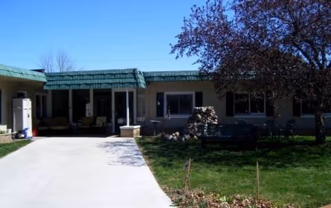 Exterior view of Sophie's Manor II, a single-story senior living facility with driveway and front lawn.