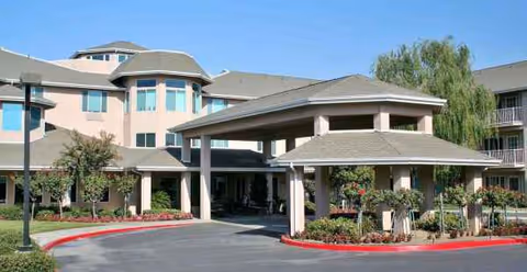 Two-story senior living facility with a covered entrance and landscaped drive in Bakersfield.
