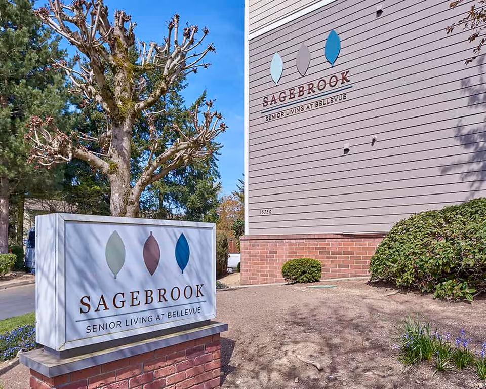 Exterior view of Sagebrook Senior Living at Bellevue showing a freestanding sign and the facility name on the building.