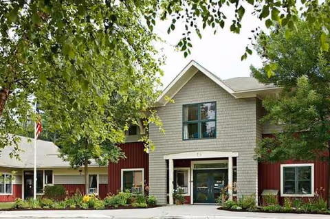 Exterior view of RiverRidge Center entrance with trees and landscaping.