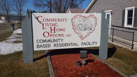 An outdoor sign for Community Living Home Options LLC at a residential facility.