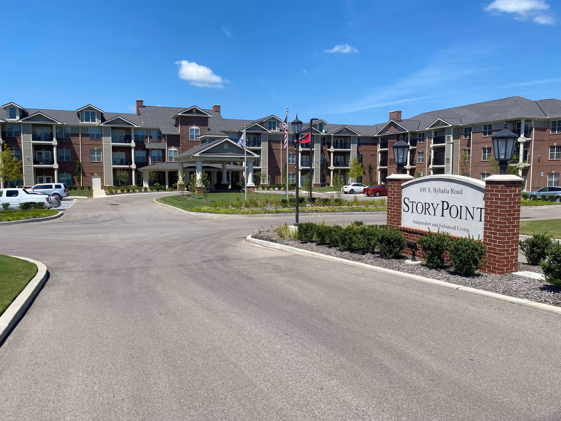 Front entrance of the StoryPoint Collierville senior living community with a driveway, landscaped grounds, and a prominent StoryPoint sign.