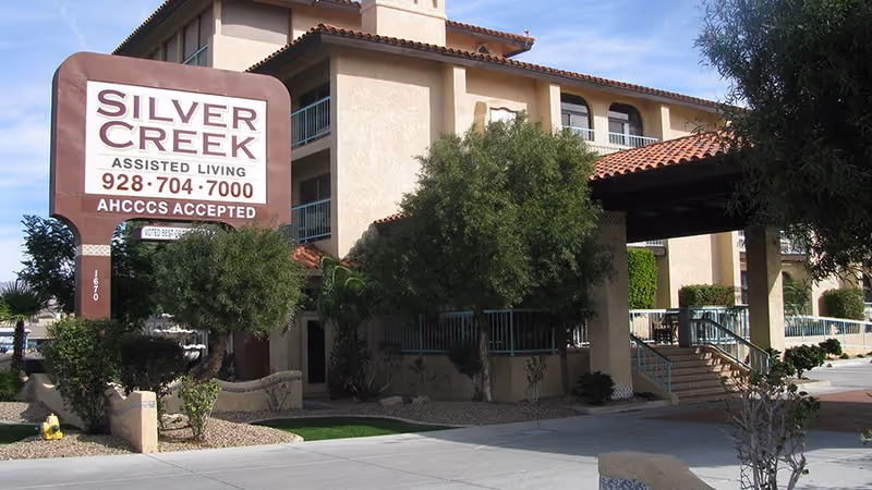 Exterior view of Silver Creek Assisted Living facility with sign and entrance.