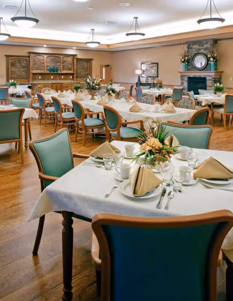 A spacious dining room at The Maples Health and Rehabilitation with elegant place settings.