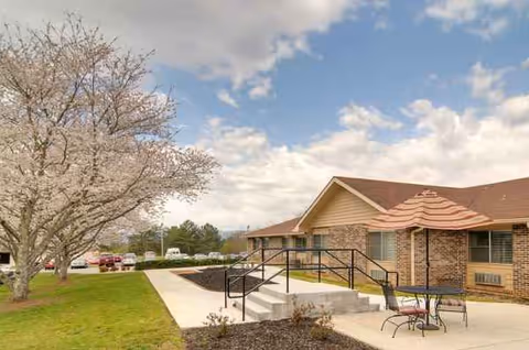 Exterior view of Life Care Center of Copper Basin with a walkway, ramp, and outdoor seating.
