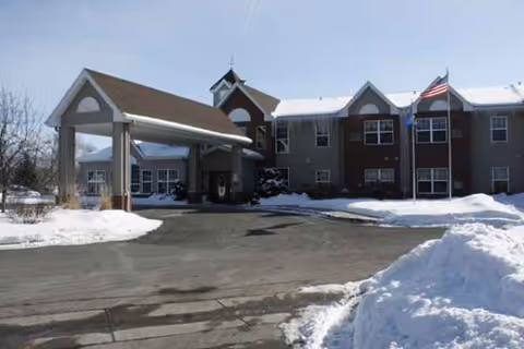 Cokato Manor exterior with a covered entrance and snow-covered parking area.